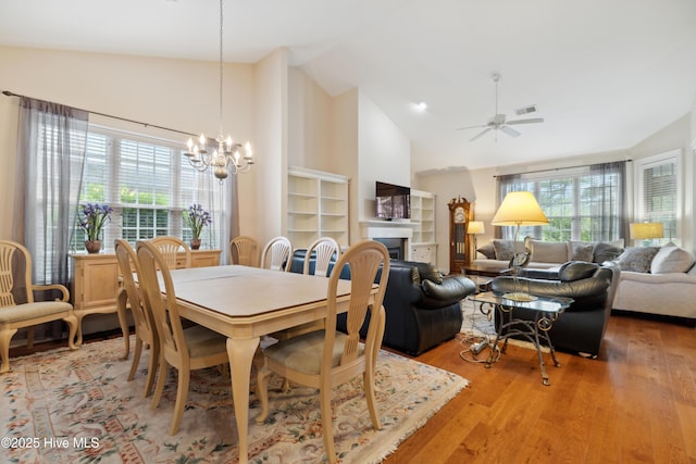 258 Morning View Way, Leland, NC 28451 - dining room with plenty of natural light, light wood-style flooring, a chandelier, a fireplace, and high vaulted ceiling