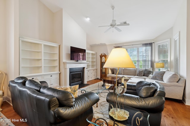 258 Morning View Way, Leland, NC 28451 - living room featuring lofted ceiling, ceiling fan, a glass covered fireplace, and wood finished floors