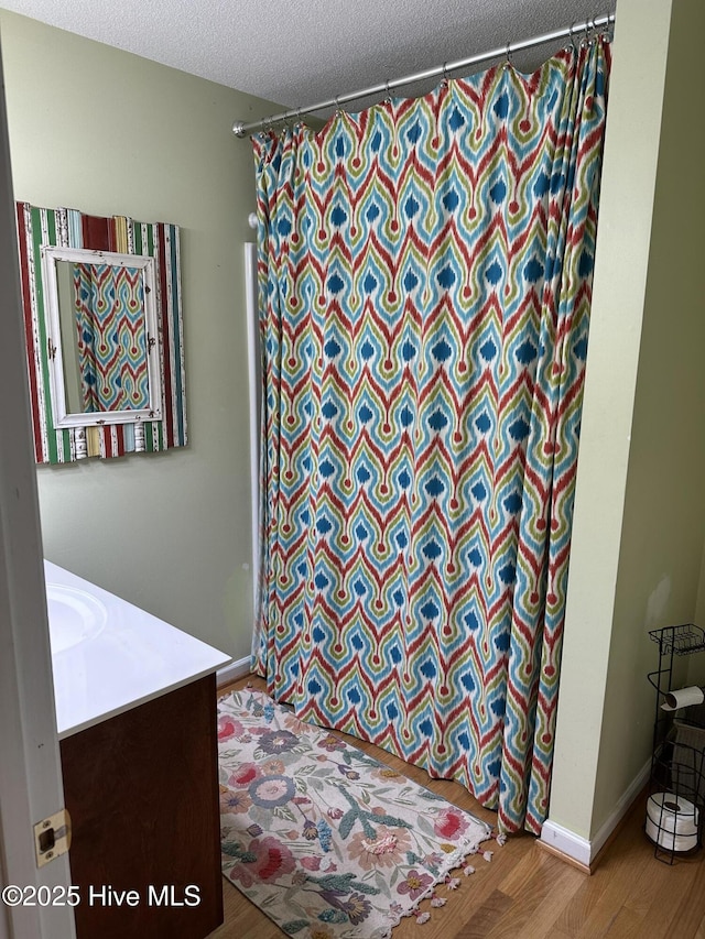 2270 Bella Coola Rd, Lake Waccamaw, NC 28450 - bathroom featuring vanity, wood finished floors, curtained shower, and a textured ceiling