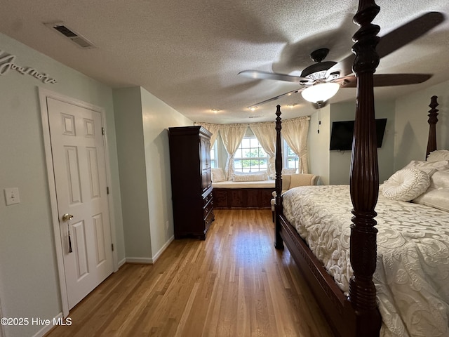 2270 Bella Coola Rd, Lake Waccamaw, NC 28450 - bedroom with light wood-style flooring, a textured ceiling, and a ceiling fan