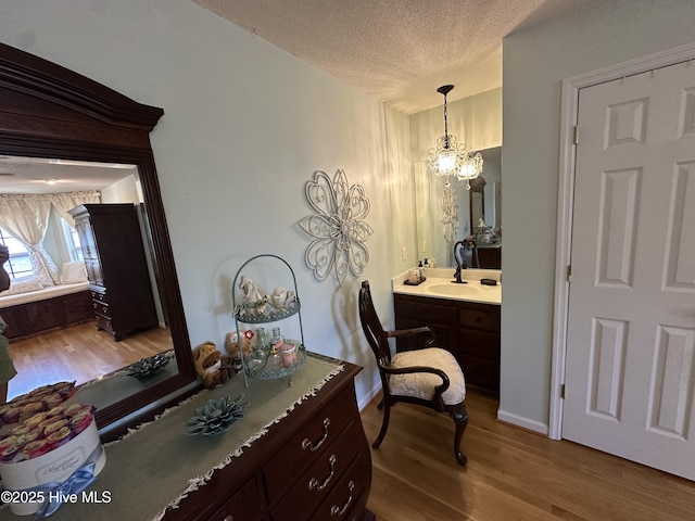 2270 Bella Coola Rd, Lake Waccamaw, NC 28450 - bathroom featuring wood finished floors, a textured ceiling, vanity, and a chandelier