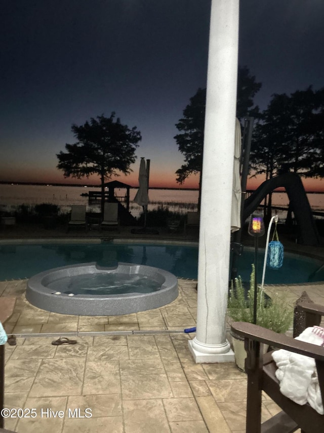 2270 Bella Coola Rd, Lake Waccamaw, NC 28450 - pool at dusk with a pool with connected hot tub and a patio