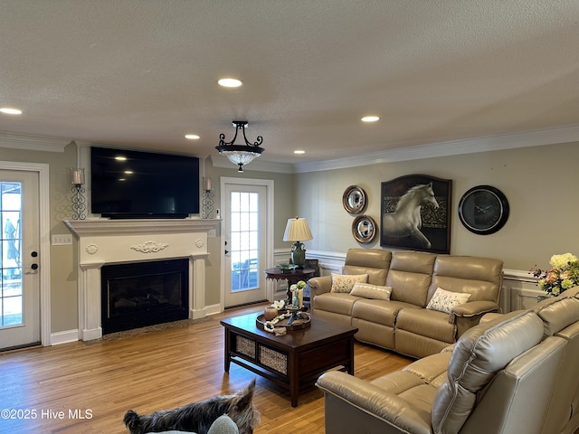 2270 Bella Coola Rd, Lake Waccamaw, NC 28450 - living area with crown molding, light wood-type flooring, a fireplace with flush hearth, plenty of natural light, and recessed lighting