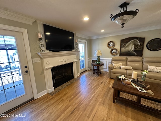 2270 Bella Coola Rd, Lake Waccamaw, NC 28450 - living room featuring crown molding, light wood finished floors, a fireplace with flush hearth, a wainscoted wall, and recessed lighting