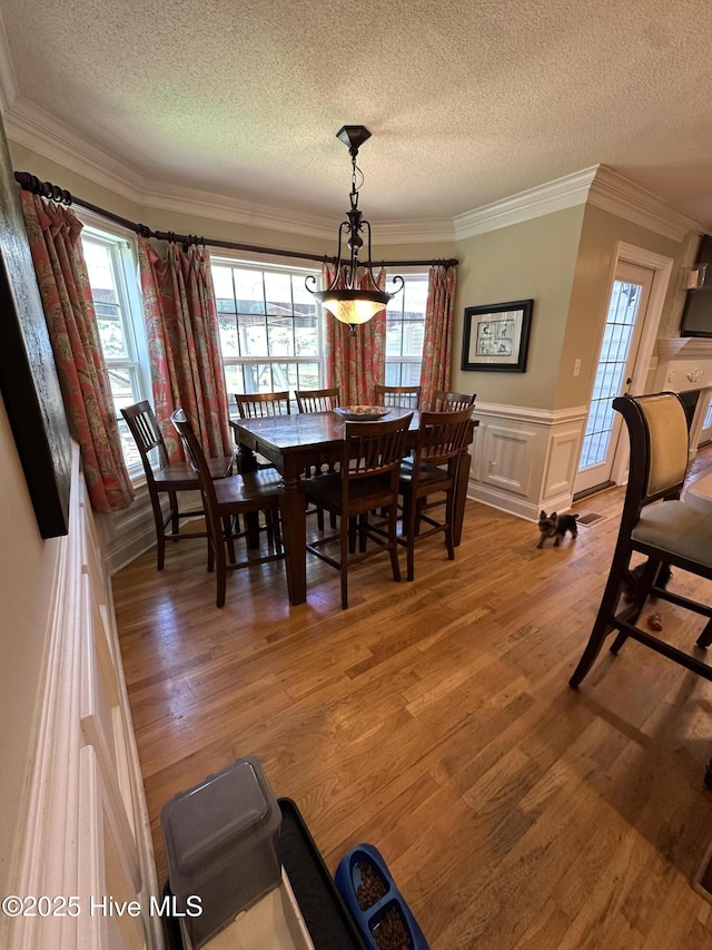 2270 Bella Coola Rd, Lake Waccamaw, NC 28450 - dining area with a textured ceiling, light wood finished floors, a wainscoted wall, and crown molding
