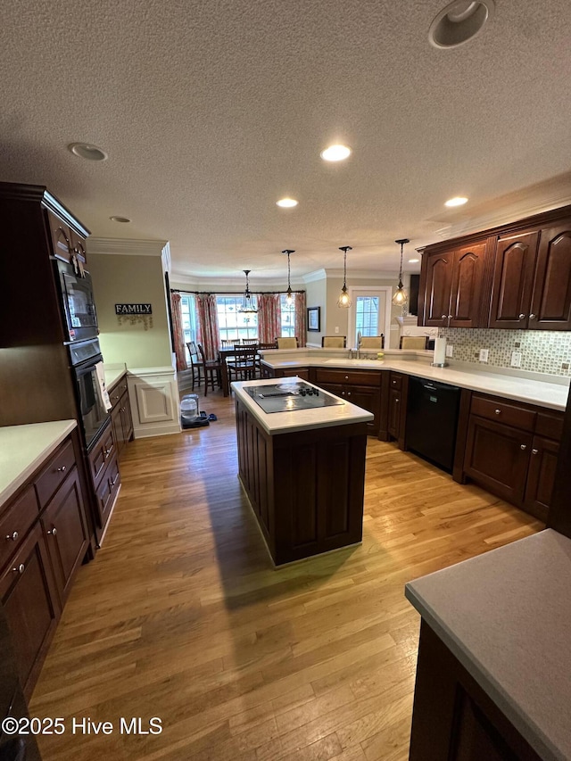 2270 Bella Coola Rd, Lake Waccamaw, NC 28450 - kitchen featuring black appliances, ornamental molding, a peninsula, dark brown cabinetry, and light wood finished floors