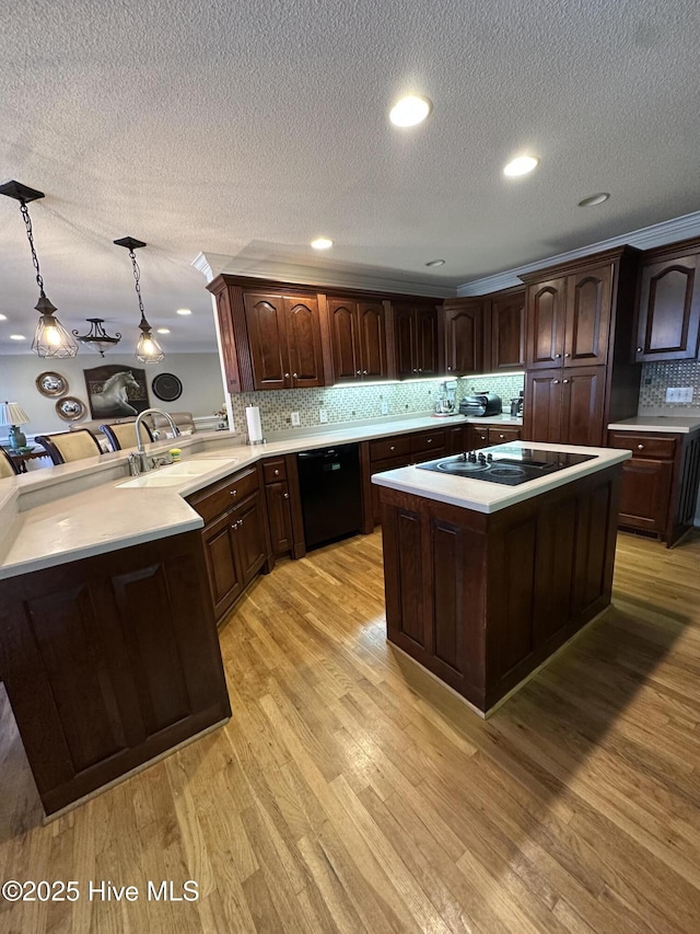 2270 Bella Coola Rd, Lake Waccamaw, NC 28450 - kitchen featuring black appliances, light countertops, backsplash, pendant lighting, and a center island