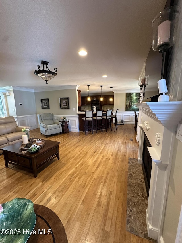 2270 Bella Coola Rd, Lake Waccamaw, NC 28450 - living room with ornamental molding, a decorative wall, a wainscoted wall, light wood-style floors, and recessed lighting