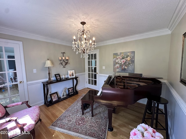 2270 Bella Coola Rd, Lake Waccamaw, NC 28450 - living area featuring a chandelier, a wainscoted wall, wood finished floors, and ornamental molding