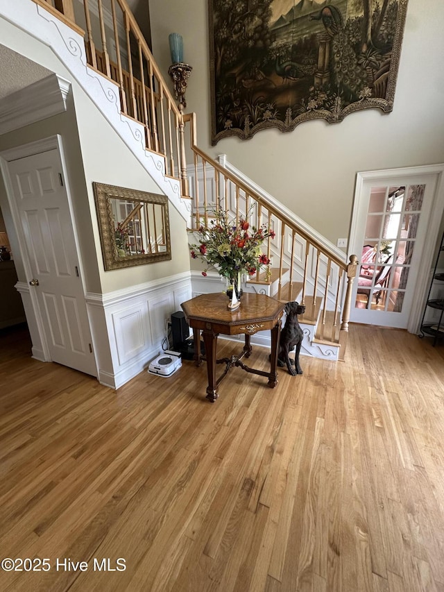 2270 Bella Coola Rd, Lake Waccamaw, NC 28450 - stairway featuring wood finished floors, a high ceiling, a wainscoted wall, and a decorative wall
