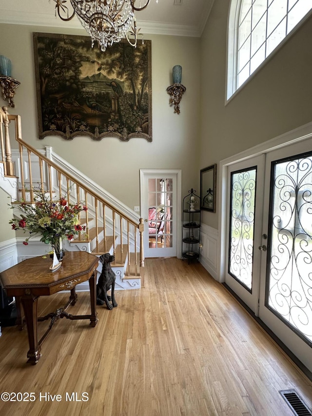 2270 Bella Coola Rd, Lake Waccamaw, NC 28450 - foyer entrance with stairway, light wood-style flooring, a towering ceiling, ornamental molding, and a chandelier