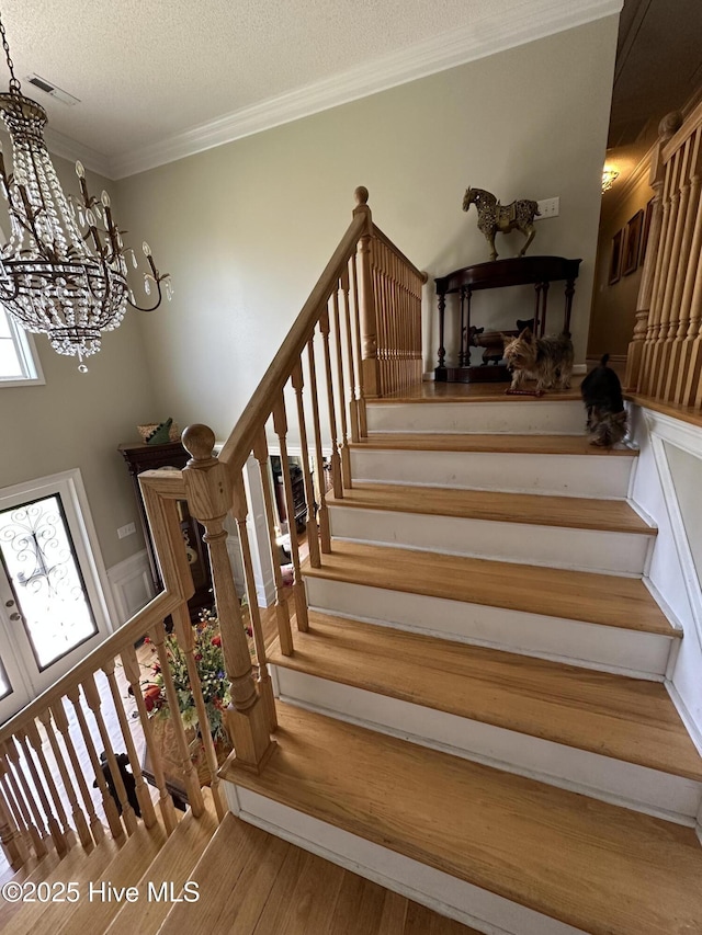 2270 Bella Coola Rd, Lake Waccamaw, NC 28450 - staircase with a chandelier, wood finished floors, crown molding, and a textured ceiling
