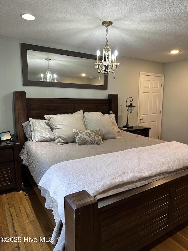 2270 Bella Coola Rd, Lake Waccamaw, NC 28450 - bedroom featuring a chandelier, wood finished floors, recessed lighting, and a textured ceiling