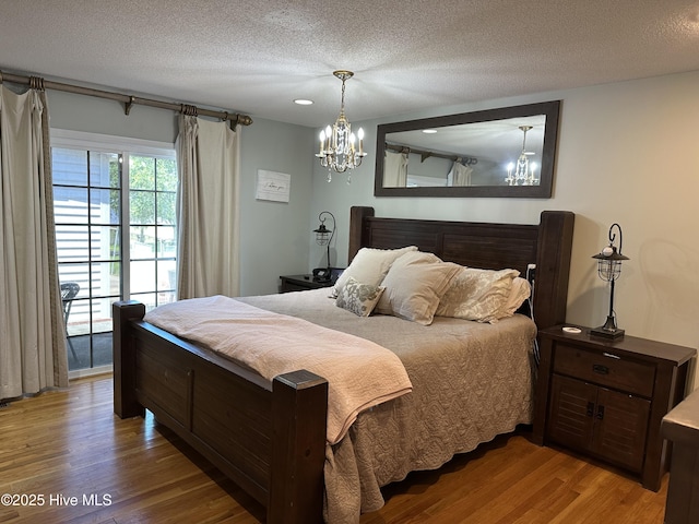 2270 Bella Coola Rd, Lake Waccamaw, NC 28450 - bedroom featuring a chandelier, wood finished floors, and a textured ceiling