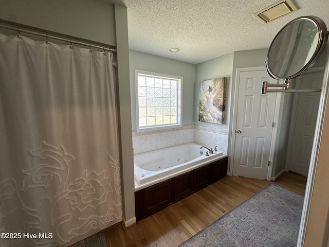 2270 Bella Coola Rd, Lake Waccamaw, NC 28450 - bathroom featuring wood finished floors, a whirlpool tub, and a textured ceiling
