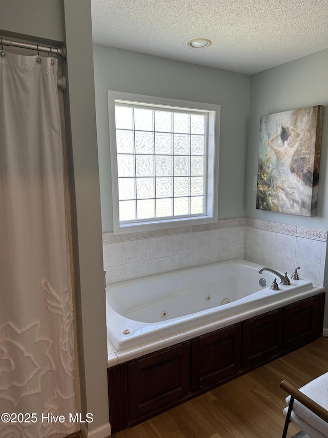 2270 Bella Coola Rd, Lake Waccamaw, NC 28450 - full bath featuring wood finished floors, a whirlpool tub, and a textured ceiling