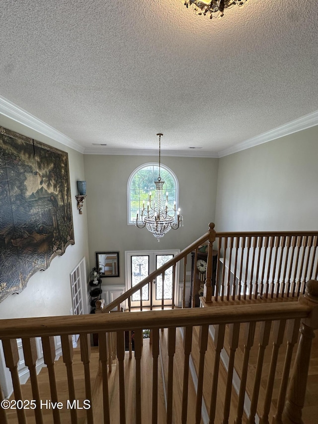 2270 Bella Coola Rd, Lake Waccamaw, NC 28450 - stairway featuring a chandelier, a textured ceiling, and crown molding