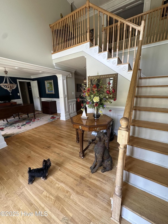2270 Bella Coola Rd, Lake Waccamaw, NC 28450 - stairs featuring a decorative wall, wood finished floors, a towering ceiling, and wainscoting