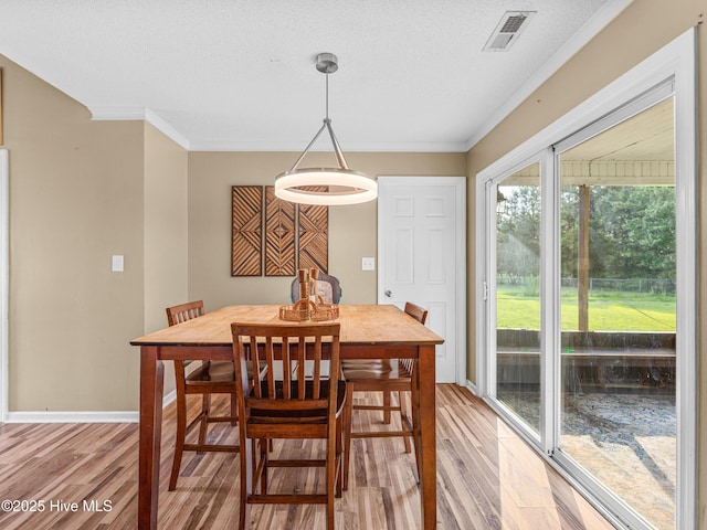165 Parnell Rd, Hubert, NC 28539 - dining room featuring light wood-type flooring, ornamental molding, and a textured ceiling