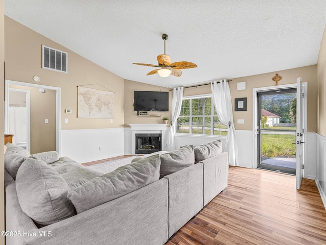 165 Parnell Rd, Hubert, NC 28539 - living area featuring vaulted ceiling, a textured ceiling, a ceiling fan, wood finished floors, and a fireplace