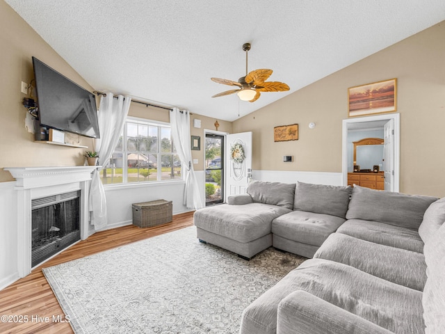 165 Parnell Rd, Hubert, NC 28539 - living room featuring vaulted ceiling, wood finished floors, a textured ceiling, a ceiling fan, and a fireplace