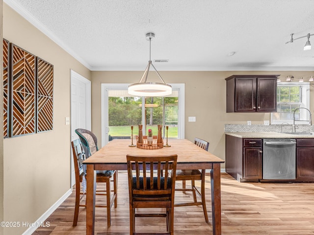 165 Parnell Rd, Hubert, NC 28539 - dining area with light wood-style floors, a textured ceiling, healthy amount of natural light, and crown molding