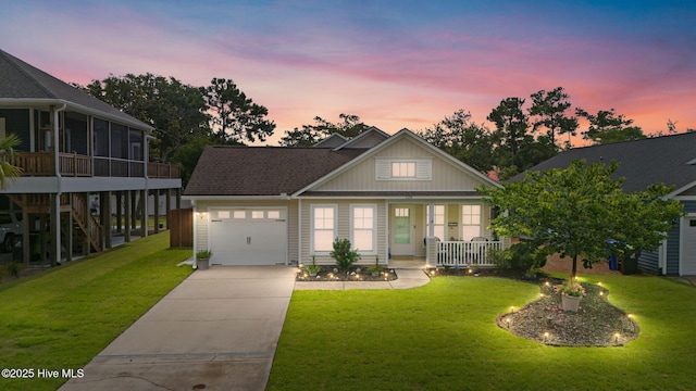 126 NW 14th St, Oak Island, NC 28465 - view of front of home with an attached garage, covered porch, driveway, and a lawn