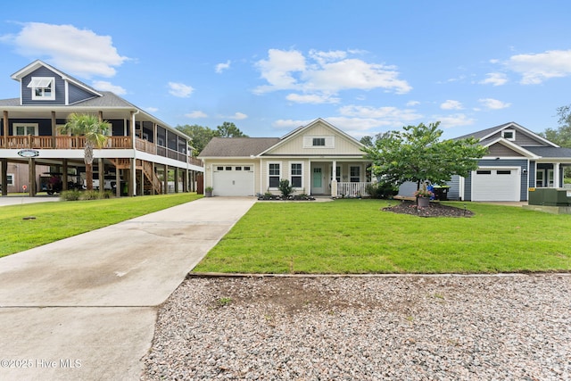 126 NW 14th St, Oak Island, NC 28465 - view of front facade featuring covered porch, driveway, an attached garage, and a front lawn