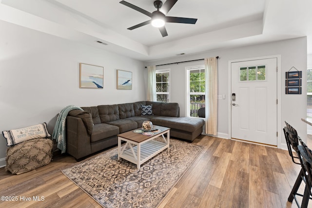 126 NW 14th St, Oak Island, NC 28465 - living room featuring a raised ceiling, light wood finished floors, and a ceiling fan