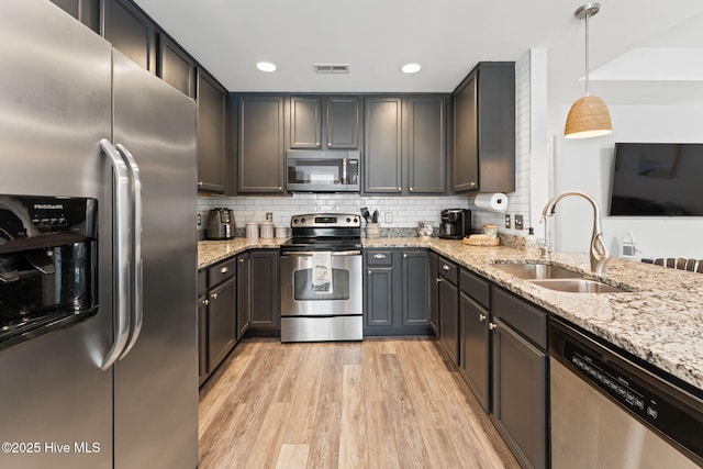 126 NW 14th St, Oak Island, NC 28465 - kitchen featuring appliances with stainless steel finishes, light wood finished floors, light stone counters, recessed lighting, and backsplash