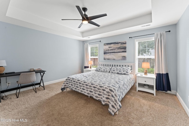 126 NW 14th St, Oak Island, NC 28465 - bedroom featuring a tray ceiling, carpet flooring, and ceiling fan