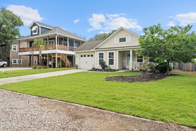 126 NW 14th St, Oak Island, NC 28465 - view of front of property featuring a porch, driveway, a garage, a front yard, and board and batten siding