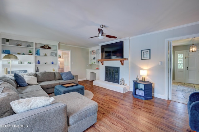 3921 Westover Rd, Wilmington, NC 28403 - living room featuring crown molding, ceiling fan, a fireplace, and light wood-style floors