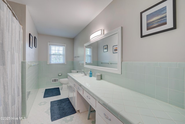 3921 Westover Rd, Wilmington, NC 28403 - bathroom with vanity, tile walls, tile patterned flooring, and wainscoting