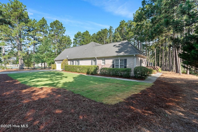 183 Baker Cir W, End, NC 27376 - view of front of house with brick siding, a front yard, and an attached garage