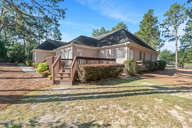 183 Baker Cir W, End, NC 27376 - view of side of property featuring brick siding, a deck, and a yard