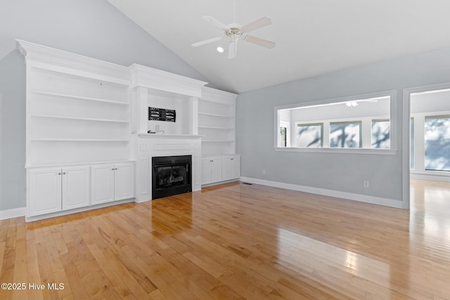 183 Baker Cir W, End, NC 27376 - unfurnished living room with light wood-style floors, a glass covered fireplace, ceiling fan, high vaulted ceiling, and built in shelves