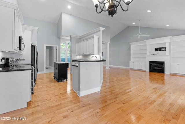 183 Baker Cir W, End, NC 27376 - kitchen featuring stainless steel microwave, dark countertops, high vaulted ceiling, ceiling fan, and a chandelier