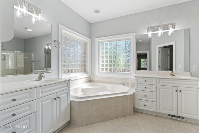 183 Baker Cir W, End, NC 27376 - full bathroom featuring two vanities, tile patterned flooring, a bath, and a stall shower