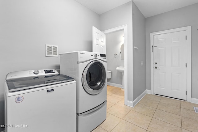 183 Baker Cir W, End, NC 27376 - laundry area featuring independent washer and dryer and light tile patterned floors