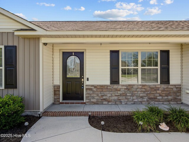 404 Bristol Ln, Hubert, NC 28539 - property entrance featuring board and batten siding, roof with shingles, and stone siding