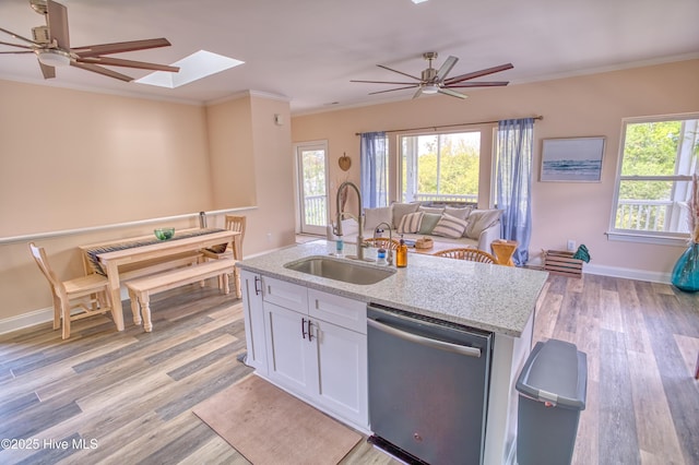 314 Spencer Farlow Dr Unit 2, Carolina Beach, NC 28428 - kitchen featuring stainless steel dishwasher, open floor plan, ceiling fan, a skylight, and white cabinets