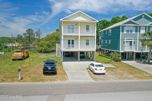 314 Spencer Farlow Dr Unit 2, Carolina Beach, NC 28428 - coastal home with a carport, driveway, a balcony, stairs, and a front lawn