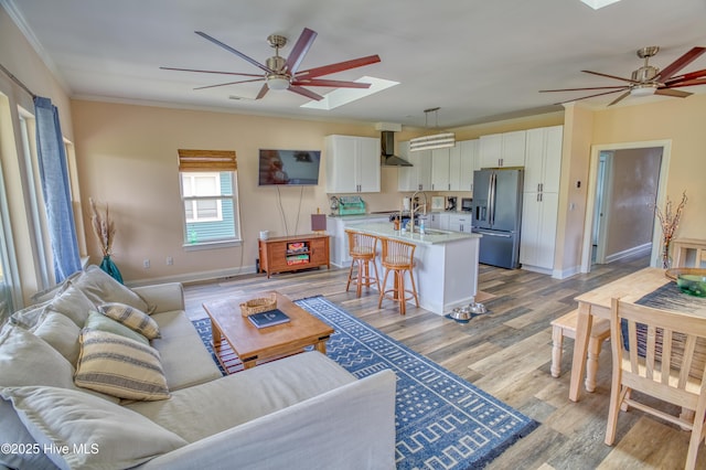 314 Spencer Farlow Dr Unit 2, Carolina Beach, NC 28428 - living room with ceiling fan, a skylight, crown molding, and light wood-style flooring