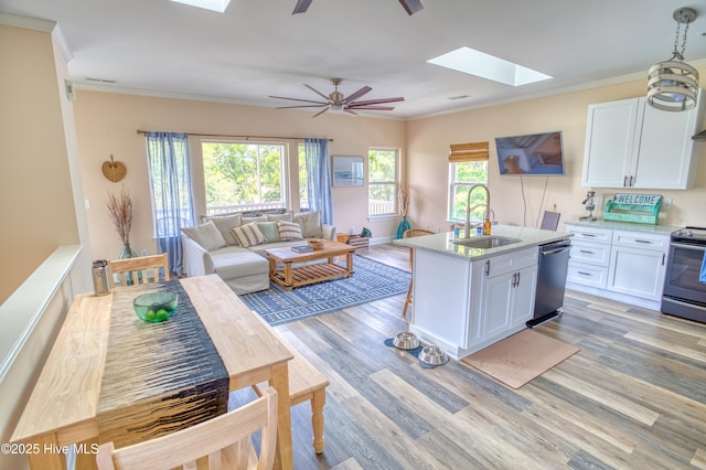 314 Spencer Farlow Dr Unit 2, Carolina Beach, NC 28428 - kitchen featuring appliances with stainless steel finishes, a skylight, ceiling fan, white cabinetry, and ornamental molding