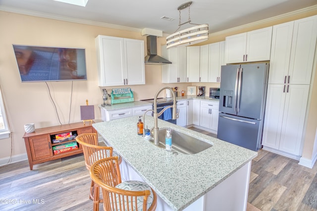 314 Spencer Farlow Dr Unit 2, Carolina Beach, NC 28428 - kitchen featuring appliances with stainless steel finishes, wall chimney range hood, white cabinetry, light wood-type flooring, and crown molding