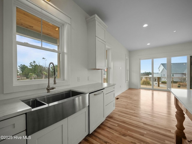 202 Topsail Watch Dr, Hampstead, NC 28443 - kitchen featuring light countertops, light wood-style floors, dishwashing machine, recessed lighting, and white cabinets