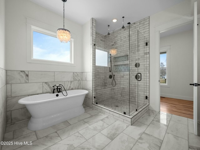 202 Topsail Watch Dr, Hampstead, NC 28443 - full bath with a stall shower, a soaking tub, marble look tiles, tile walls, and a chandelier