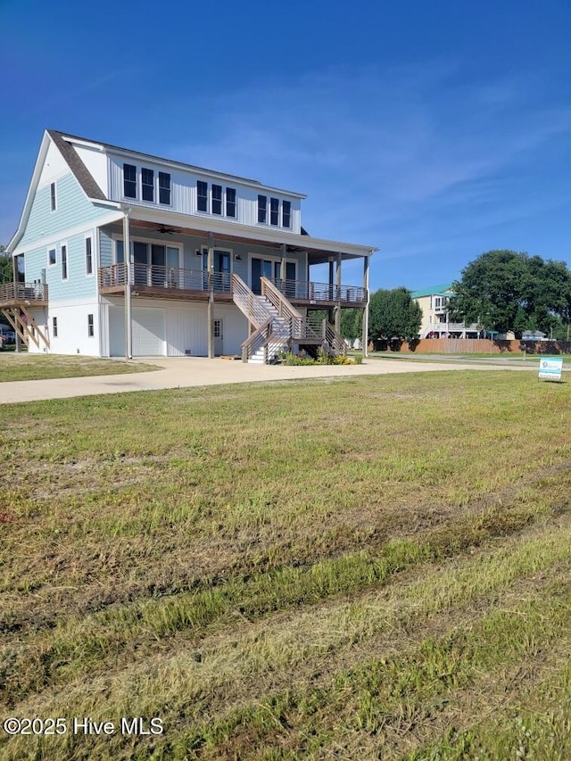 202 Topsail Watch Dr, Hampstead, NC 28443 - view of front of home with stairs, a front yard, concrete driveway, an attached garage, and covered porch