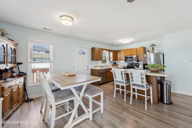 9010 W 9th St, Surf City, NC 28445 - kitchen with stainless steel appliances, a breakfast bar area, light countertops, and light wood finished floors